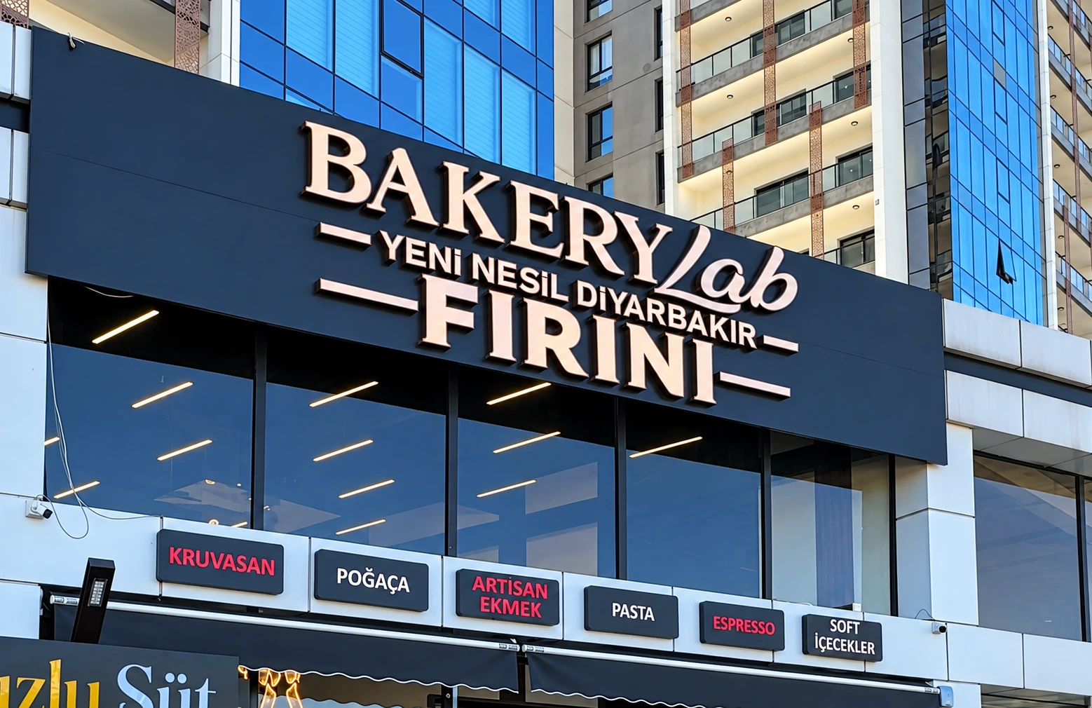 Bakery Lab façade: the BakeryLab New-Generation Diyarbakır Bakery sign with boards for Croissant, Poğaça, Artisan Bread, Cake, Espresso and Soft Drinks beneath